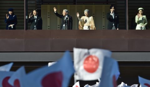 From the balcony of the Imperial Palace, Emperor Akihito greets thousands of people, waving Japanese flags, who have gathered to wish him a happy 82nd birthday on December 23, 2014.