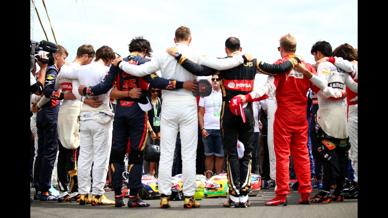The Bianchi family and fellow drivers observe a minute's silence as they form a huddle around their helmets, including the late Bianchi's, before the start of the Hungarian GP at the Hungaroring on July 26, 2015 in Budapest, Hungary.