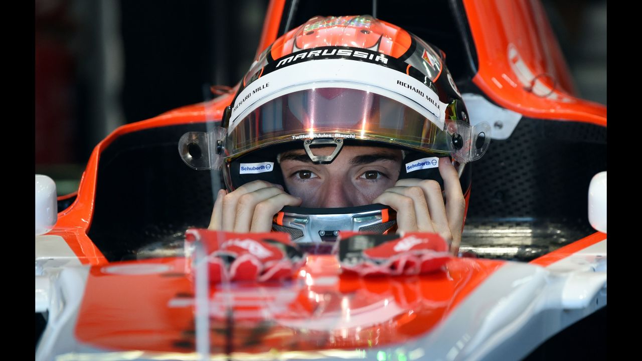 Bianchi puts on his helmet in the pits during the first practice session ahead of the German GP at the Hockenheimring in Hockenheim, Germany on July  18, 2014. 
