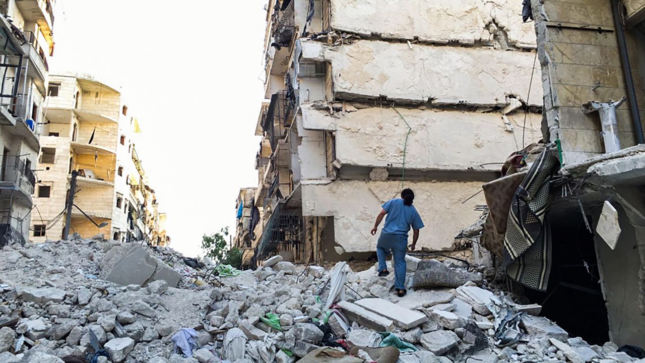 Dr. Samer Attar walking across the rubble of bombed out buildings in rebel-held eastern Aleppo.