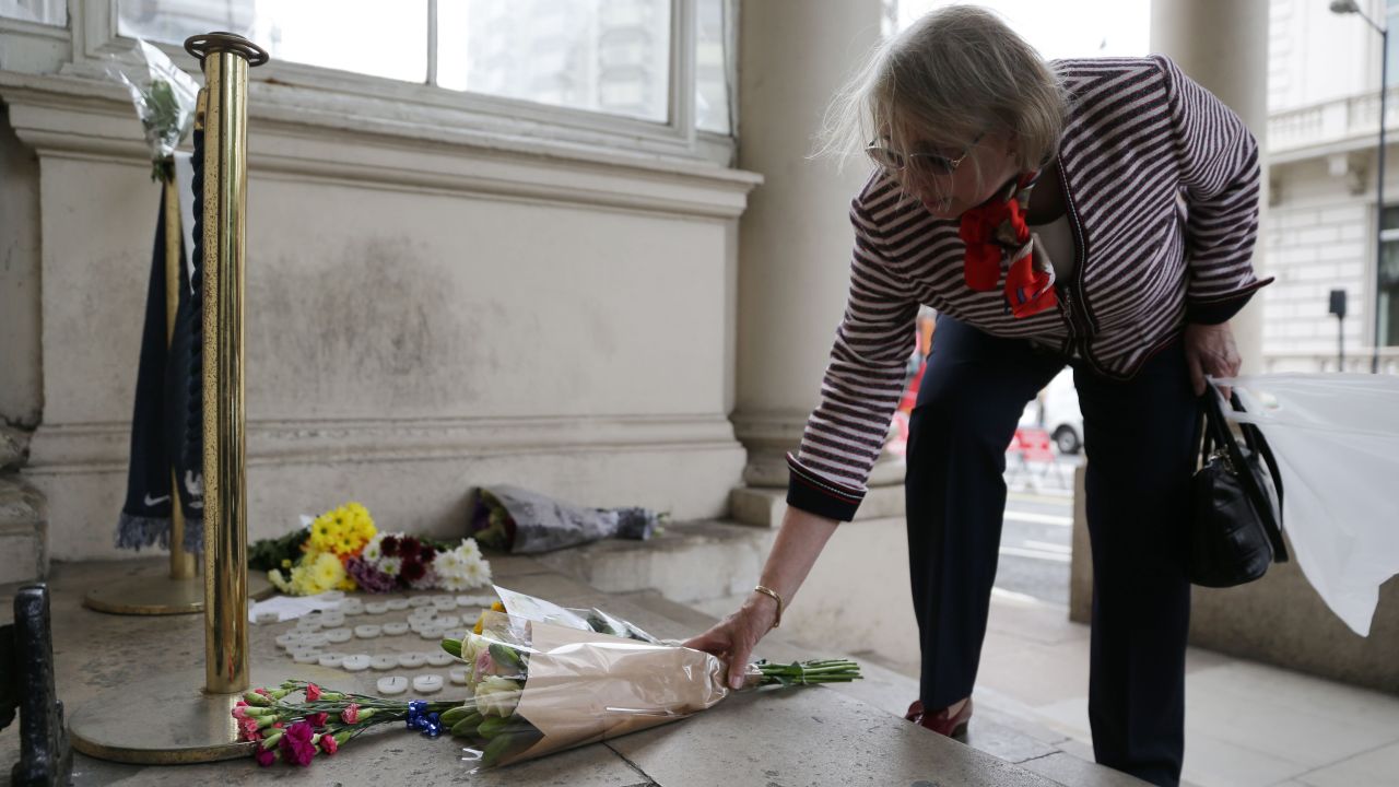 A woman places flowers outside the French Embassy in London.