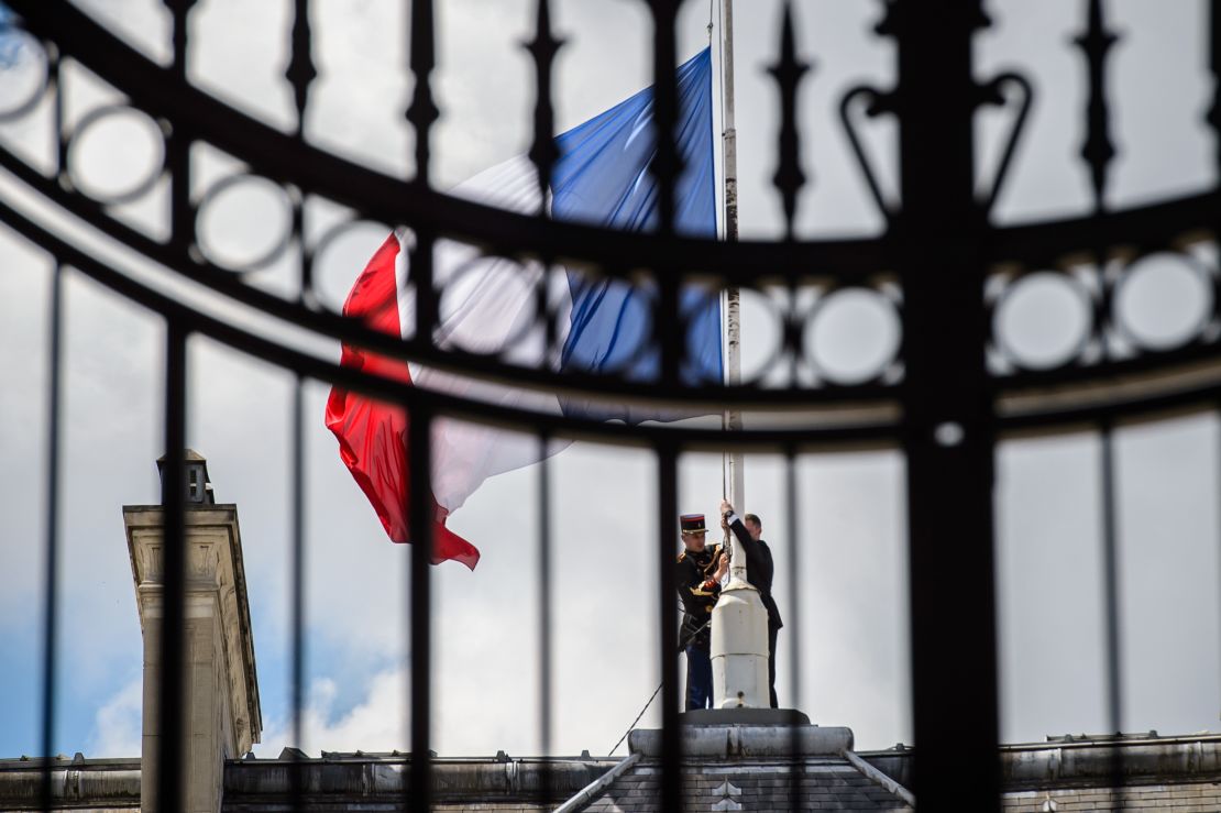 French Republican guards place the French flag half-staff at the Elysee presidential Palace on Friday.