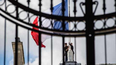 French Republican guards place the French flag half-staff at the Elysee presidential Palace on Friday.