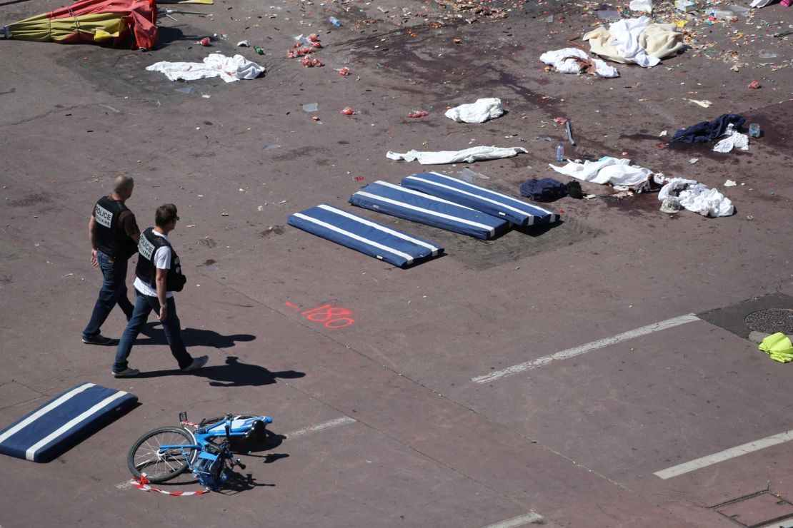 Policemen walk the attack site, on the Promenade des Anglais seafront, in Nice.