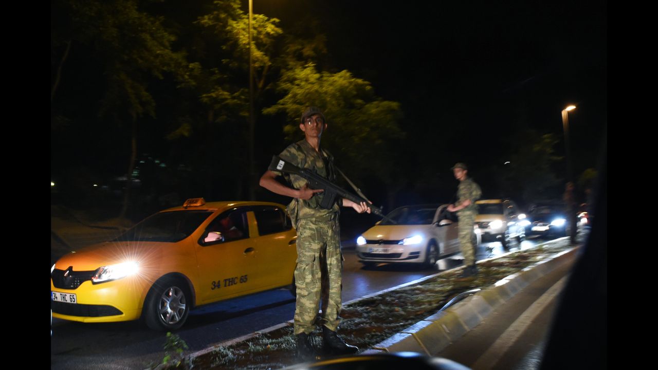 A Turkish security officer stands guard on the side of the road.