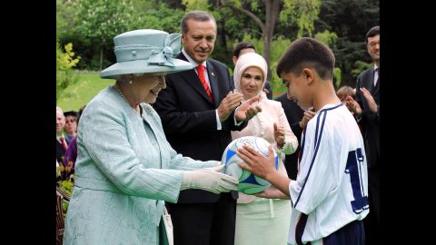 Britain's Queen Elizabeth II, accompanied by Erdogan and his wife Emine Erdogan, gives a David Beckham signed soccer ball to a Turkish boy during at a garden party held for her birthday at the British Embassy in Ankara, Turkey, on May 16, 2008. It was the Queen's first visit to Turkey in 37 years.