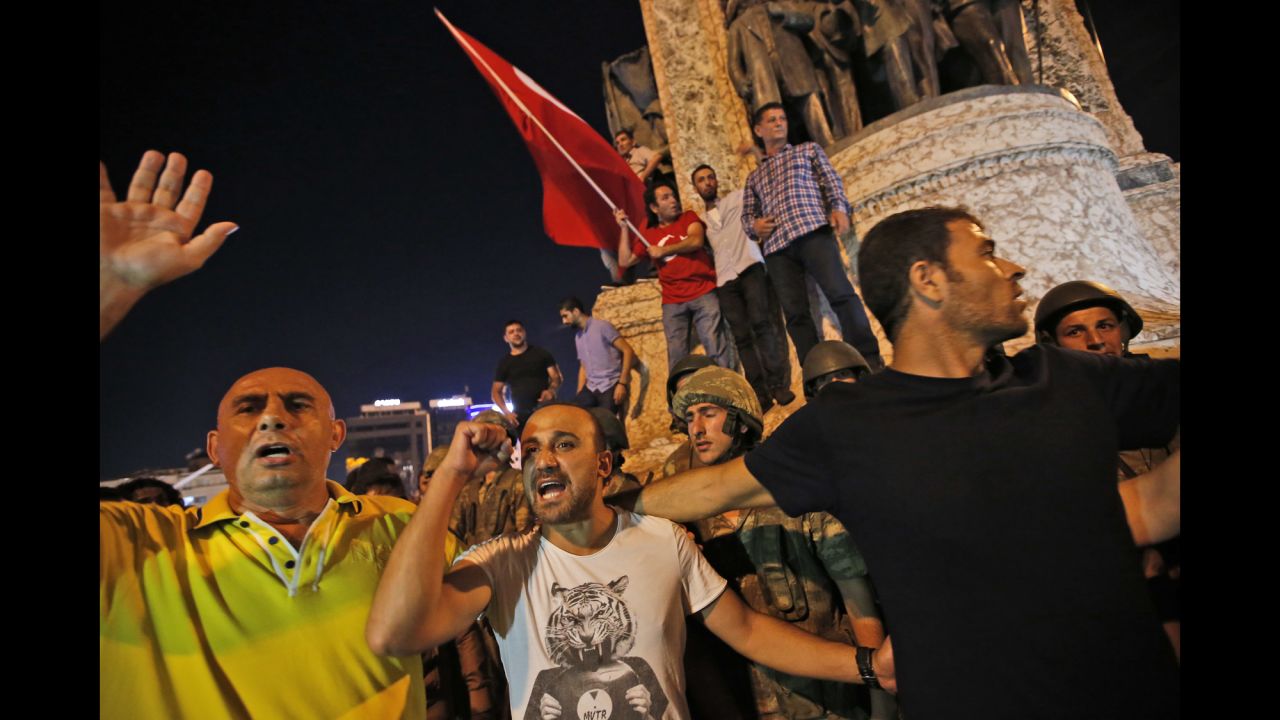 Supporters of President Recep Tayyip Erdogan protest in front of soldiers in Istanbul's Taksim Square.