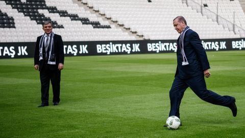 Erdogan, right, kicks a soccer ball while Former Turkish President Abdullah Gul watches at Besiktas soccer club's new Vodafone Arena on its opening day in Istanbul on Sunday, April 10.