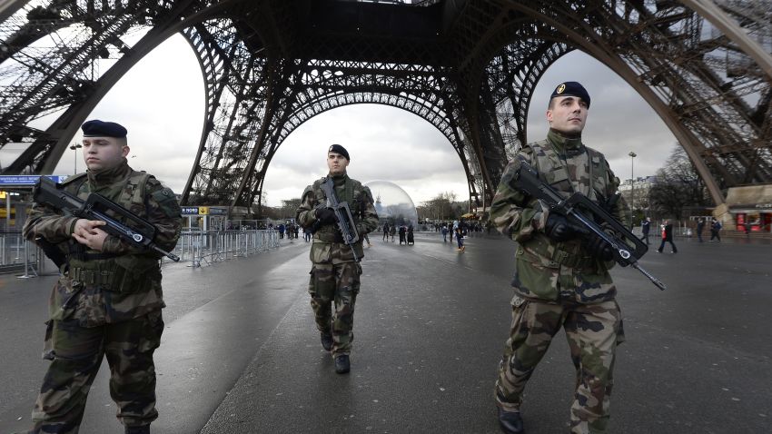 French soldiers patrol in front of the Eiffel Tower on January 8, 2015 in Paris as the capital was placed under the highest alert status a day after heavily armed gunmen shouting Islamist slogans stormed French satirical newspaper Charlie Hebdo and shot dead at least 12 people in the deadliest attack in France in four decades. A  huge manhunt for two brothers suspected of massacring 12 people in an Islamist attack at a satirical French weekly zeroed in on a northern town Thursday after the discovery of one of the getaway cars. As thousands of police tightened their net, the country marked a rare national day of mourning for Wednesday's bloodbath at Charlie Hebdo magazine in Paris, the worst terrorist attack in France for half a century. AFP PHOTO / BERTRAND GUAY        (Photo credit should read BERTRAND GUAY/AFP/Getty Images)