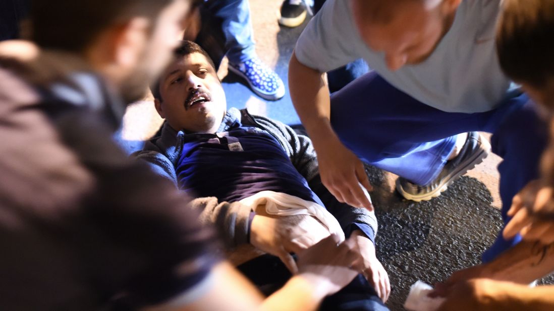 A wounded man is given medical care at the entrance to the Bosphorus Bridge in Istanbul after clashes with Turkish military.