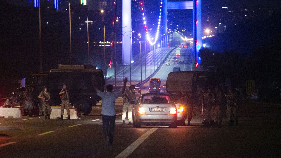 A man approaches Turkish military with his hands up at the entrance to the partially closed Bosphorus Bridge in Istanbul.
