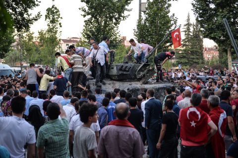 People gather on top of a Turkish military tank in Ankara in the morning after the coup attempt. National intelligence officials said the coup was put down and that the government remains in control. 