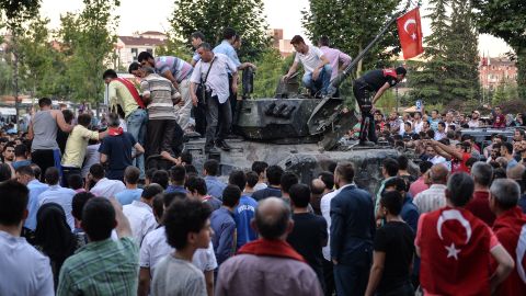 People gather on top of a Turkish military tank in Ankara in the morning after the coup attempt. National intelligence officials said the coup was put down and that the government remains in control.
