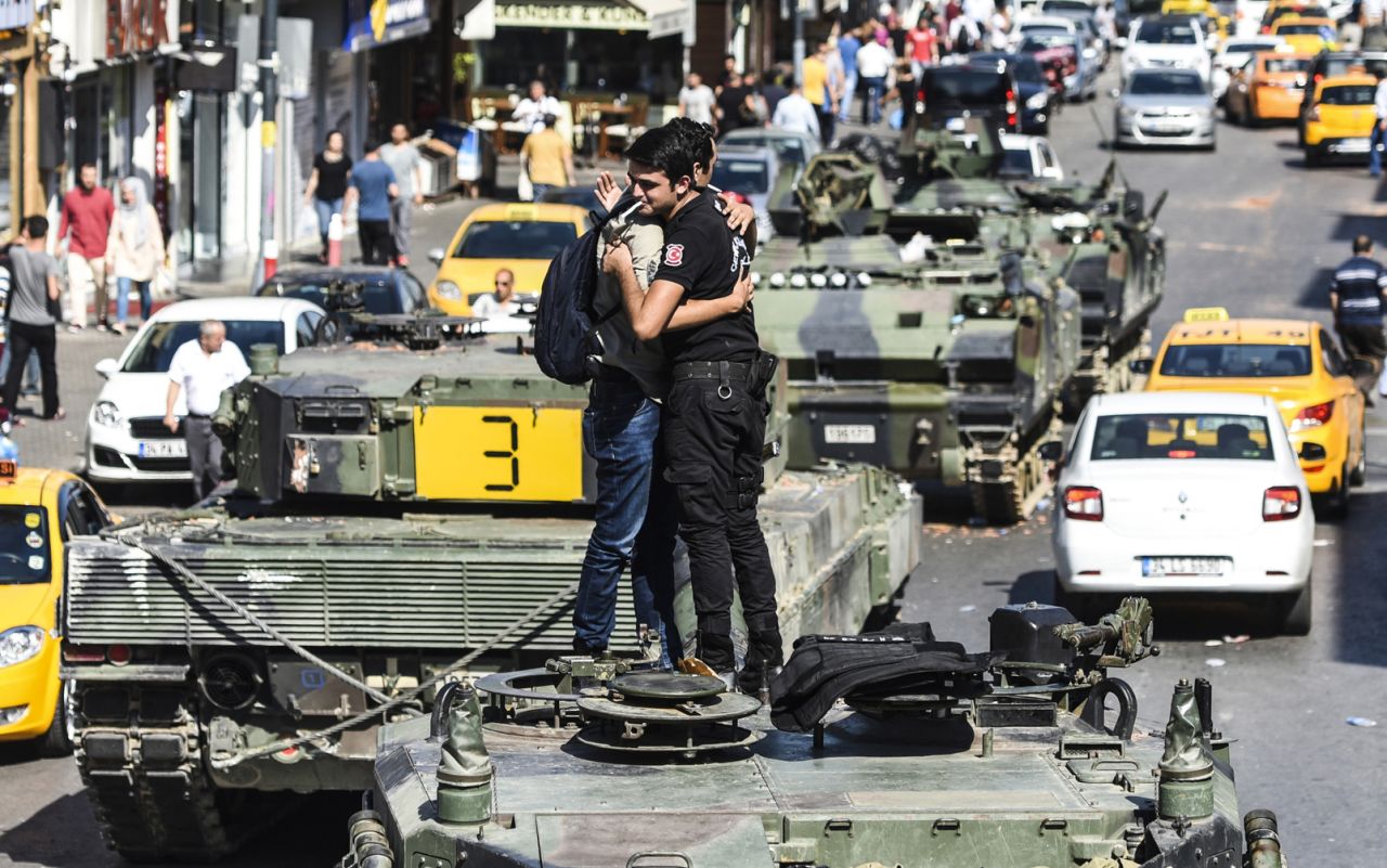A Turkish police officer in Istanbul embraces a man on a tank in the wake of the violence overnight.