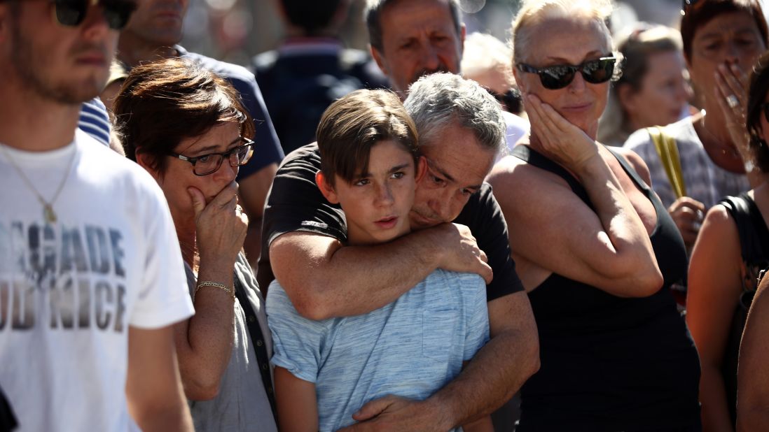 A boy is comforted as people gather and lay tributes on the Promenade des Anglais on Saturday, July 16 in Nice, France. 