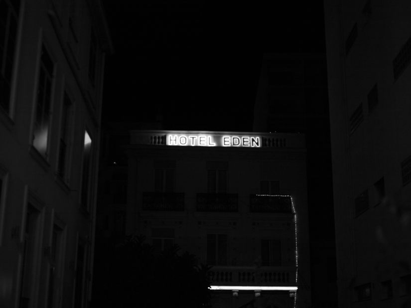 A hotel sign is lit up in the night.