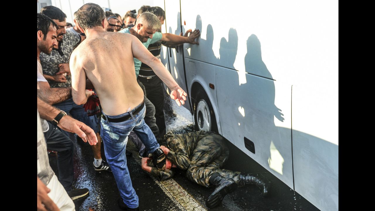 People kick a Turkish soldier who participated in the attempted coup, on Istanbul's Bosphorus Bridge.