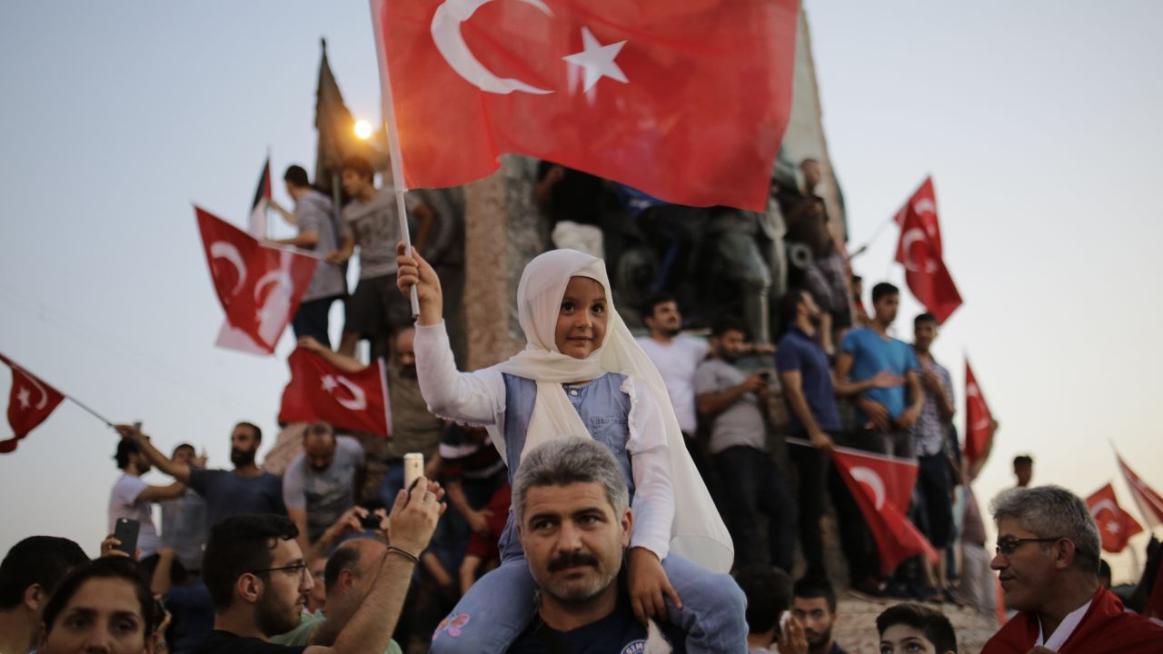 People wave flags in Istanbul's Taksim Square on Saturday in support of the President.