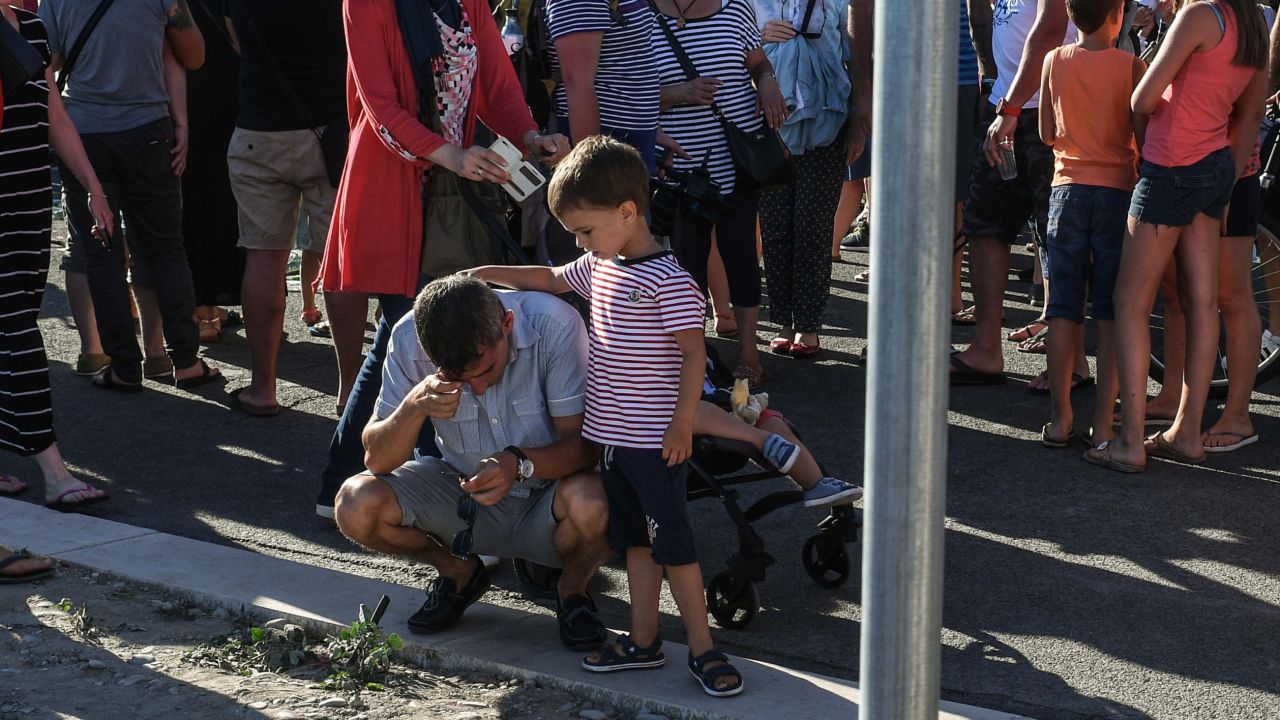 A young boy comforts his father Saturday on the Promenade des Anglais in Nice.