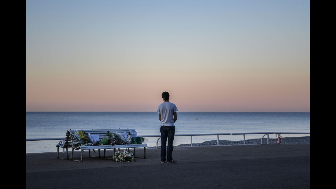 A man takes in a tribute to the Nice victims left on a bench near the site of the attack on the Promenade des Anglais on July 17.