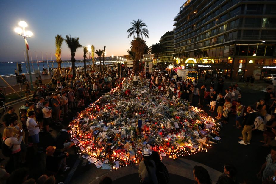 People gather at a makeshift memorial on the Promenade des Anglais in Nice on Sunday, July 17. ISIS has claimed responsibility for the truck rampage, but the French interior minister said that any link between the attacker -- Mohamed Lahouaiej-Bouhlel -- and the terror group has yet to be established.