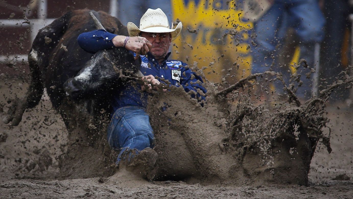 Casey Martin wrestles a steer in the mud during the Calgary Stampede on Sunday, July 17.