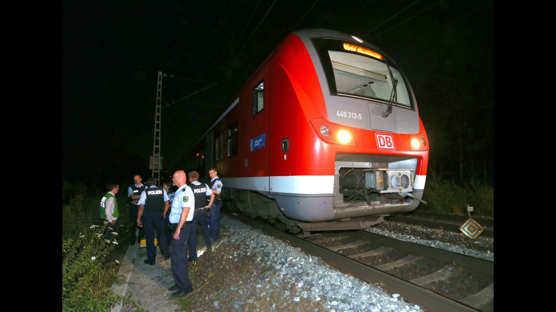 Police stand by a regional train in Wurzburg, Germany, on Monday, July 18, after authorities said a man attacked passengers with an ax. German police shot the man dead in a confrontation after he fled the train. Four passengers who were attacked are in serious condition, police said.