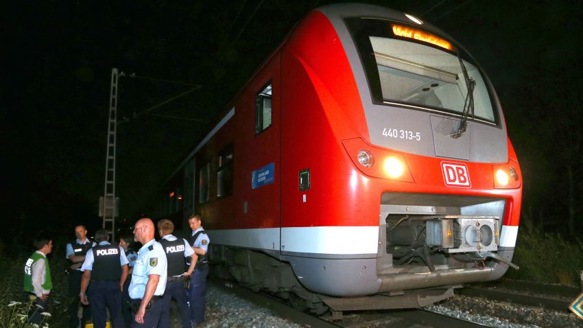 Police officers stand by a regional train in Wuerzburg southern Germany on July 18, 2016 after a man attacked train passengers with an axe. 
German police killed the man after he attacked passengers on a train with an axe and a knife, seriously wounding three people, news agency DPA reported citing police.