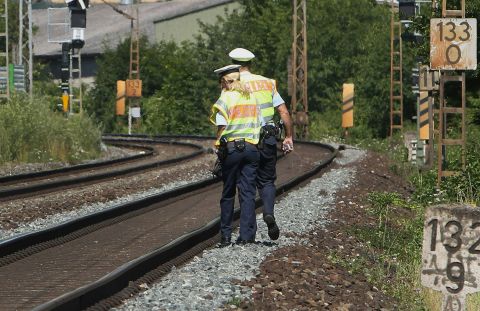 Officers walk along train tracks in Wurzburg on July 19, a day after the attack. German authorities said they had found a hand-drawn flag resembling the one used by ISIS among the Afghan man's belongings. A pro-ISIS media group said the attacker was an "ISIS fighter," but authorities cast doubt on that claim.