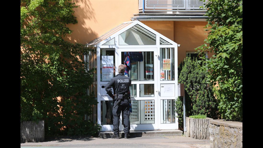 A police officer enters the Kolping House in Ochsenfurt on Tuesday, July 19, where the attacker reportedly lived with other refugees until two weeks ago. The attacker came to Germany without his parents a year ago,  police said.