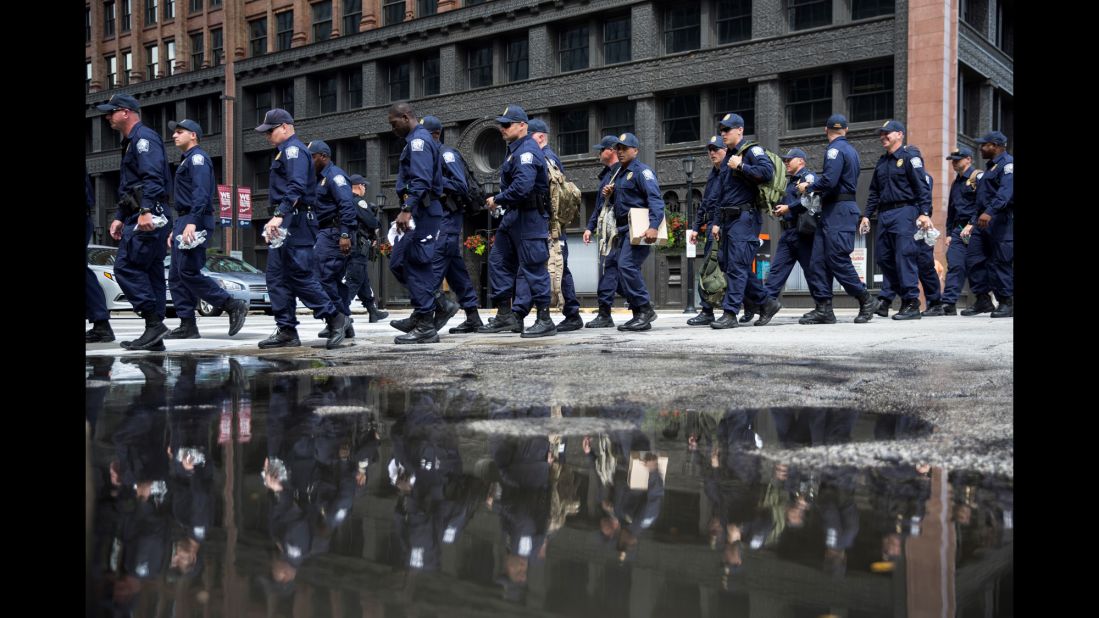 Police officers walk to designated protest areas on Monday.