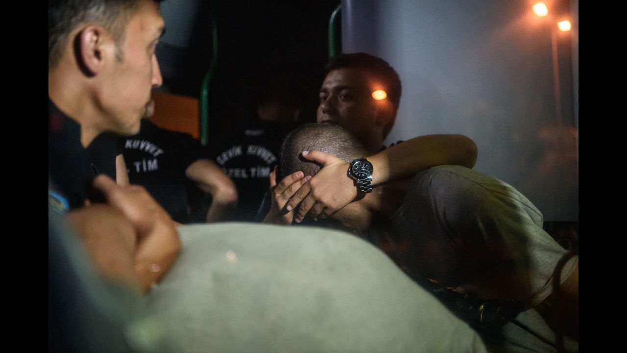 Turkish police officers cover the eyes of soldiers as they are transported in a bus from the courthouse in Istanbul on July 16.