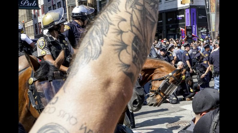 Two officers sustained minor injuries, and several people were arrested, after a protester attempted to light an American flag on fire Wednesday outside the security barrier surrounding the convention.