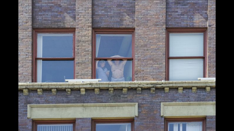 People watch the arrests from their window.