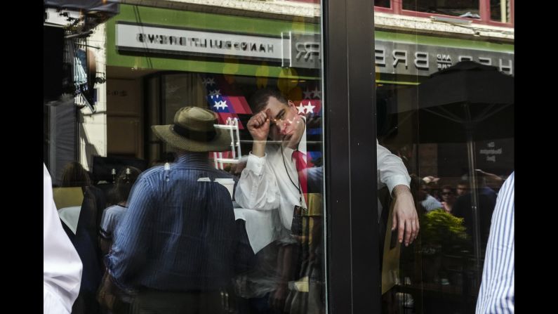 A convention-goer sits inside a restaurant during lunchtime. 