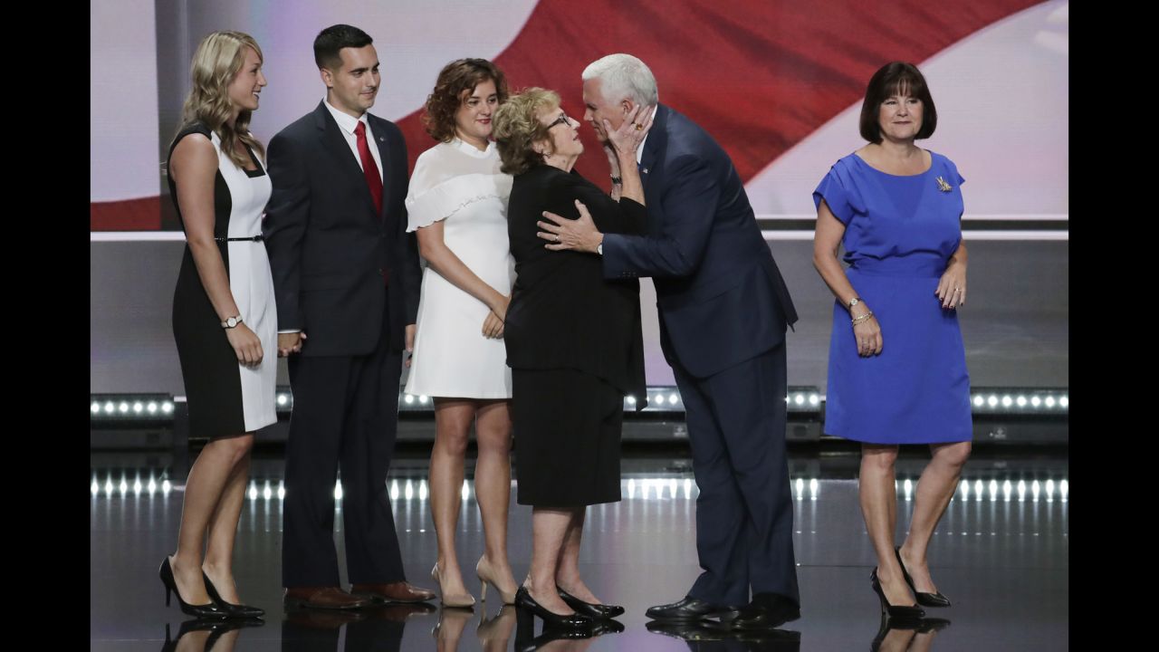 Pence receives a kiss from his mother, Nancy, as his family joins him on stage after his speech.