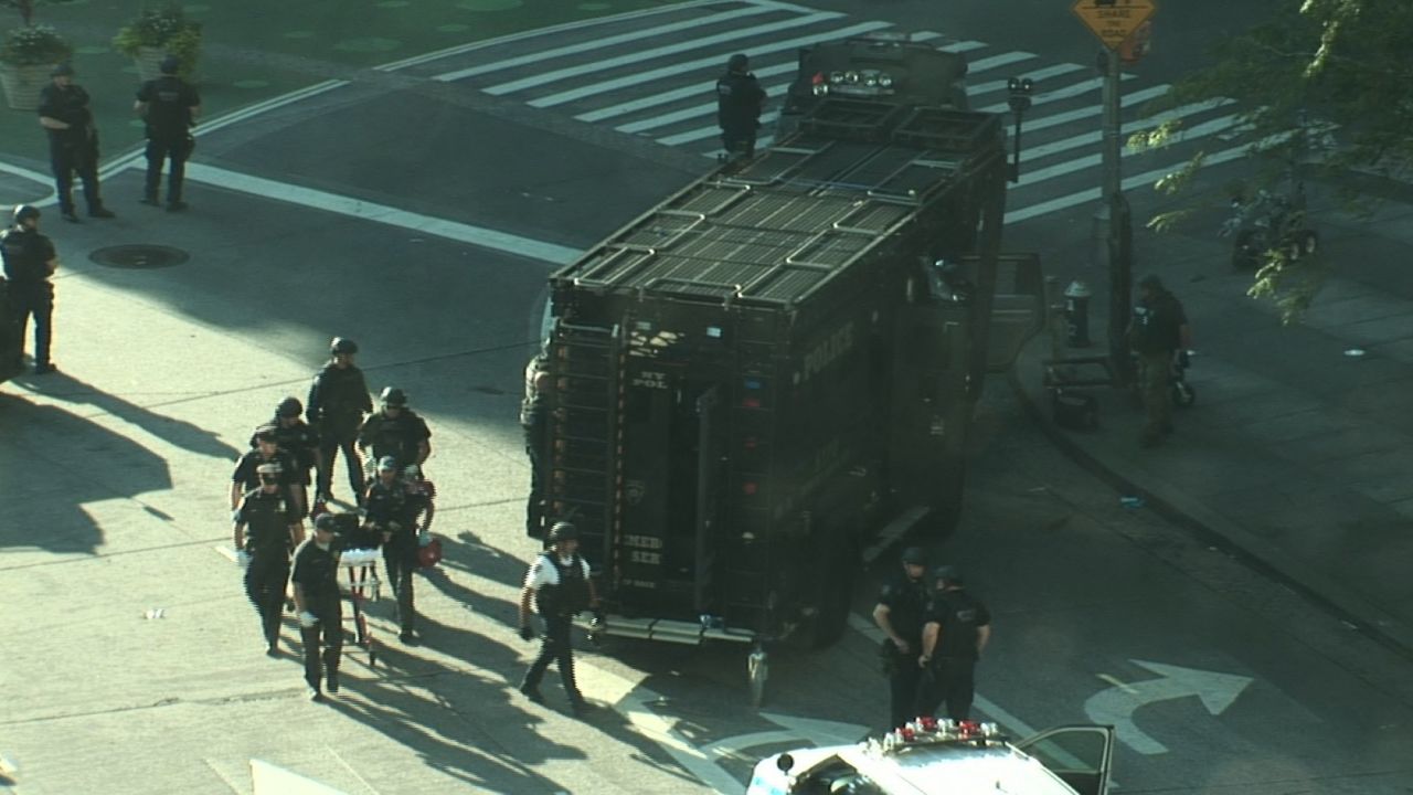 New York police on Thursday wheel away a man suspected of tossing a device into a marked police van.