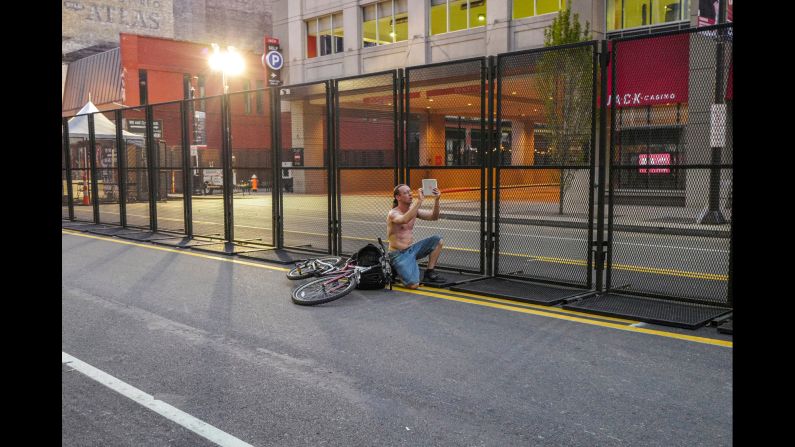 A man takes a photo outside the protective perimeter of the convention.