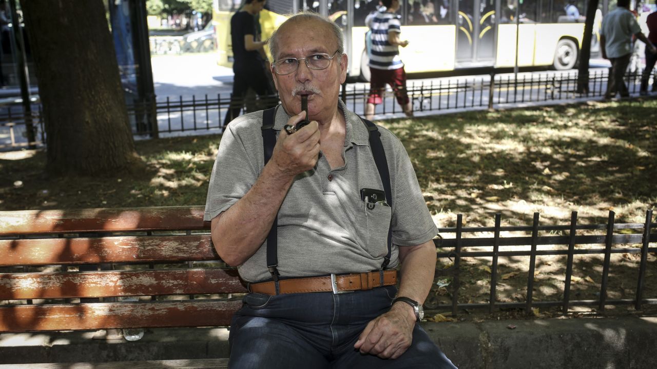Ali, a teacher, smokes his pipe as he poses for a photo, in Istanbul.