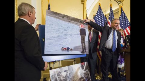 Kaine shows the photo of a 3-year-old drowned Syrian boy during a Capitol Hill news conference in 2015. Politicians and religious leaders had come together to discuss the Syrian refugee crisis.
