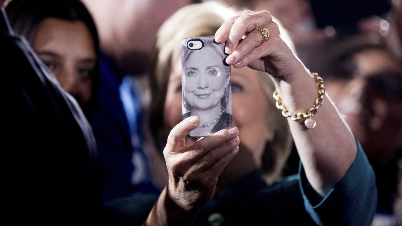 Presidential candidate Hillary Clinton uses a phone bearing her likeness as she takes selfies with supporters in Las Vegas on Tuesday, July 19.