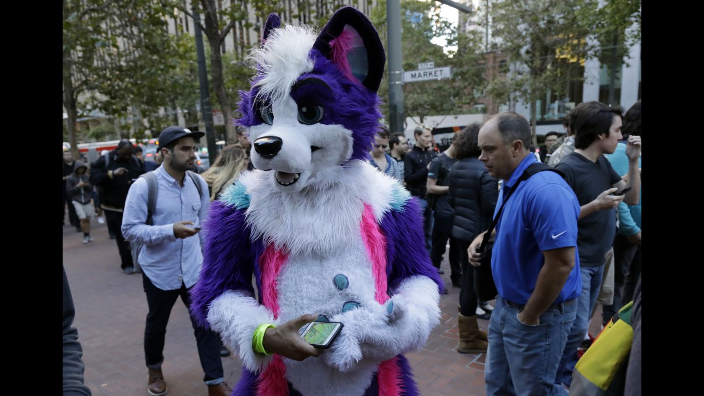 A man wears a costume as he walks in San Francisco with other "Pokemon Go" players on Wednesday, July 20. The mobile game <a href="http://money.cnn.com/2016/07/19/investing/pokemon-go-nintendo-shares/index.html" target="_blank">has been a sensation</a> for its company, Nintendo.