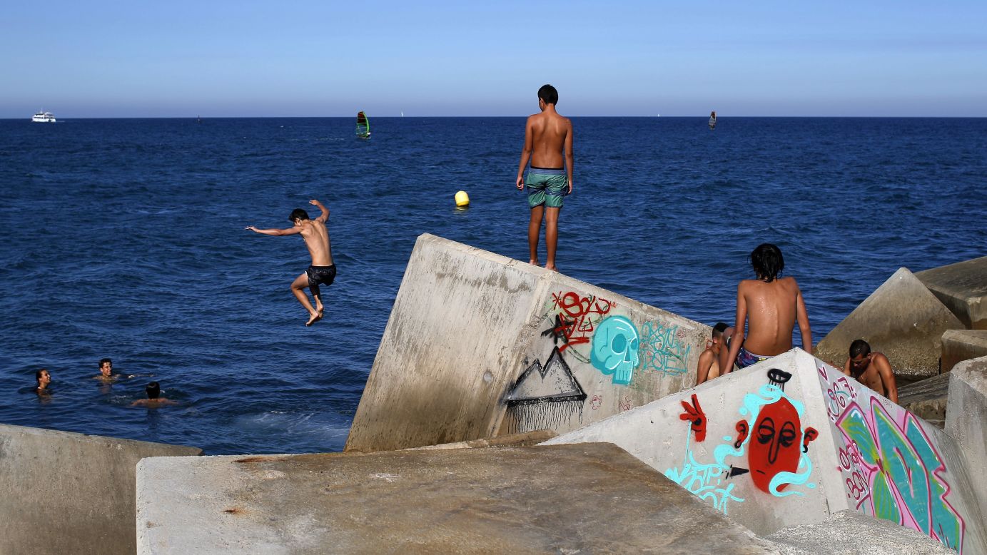 A boy jumps into the sea during a hot day in Barcelona, Spain, on Tuesday, July 19.