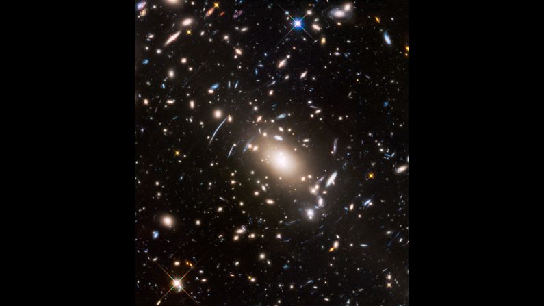 Gravitational lensing and space warping are visible in this image of near and distant galaxies captured by Hubble.