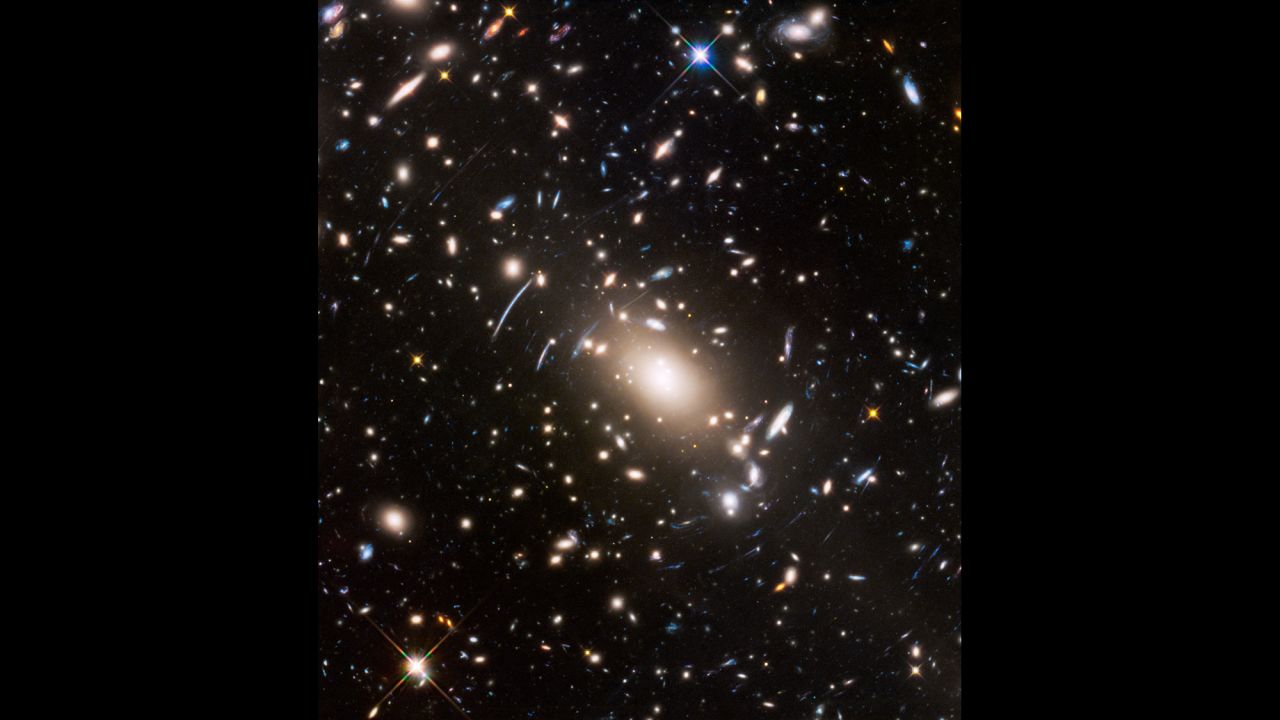 Gravitational lensing and space warping are visible in this image of near and distant galaxies captured by Hubble. 