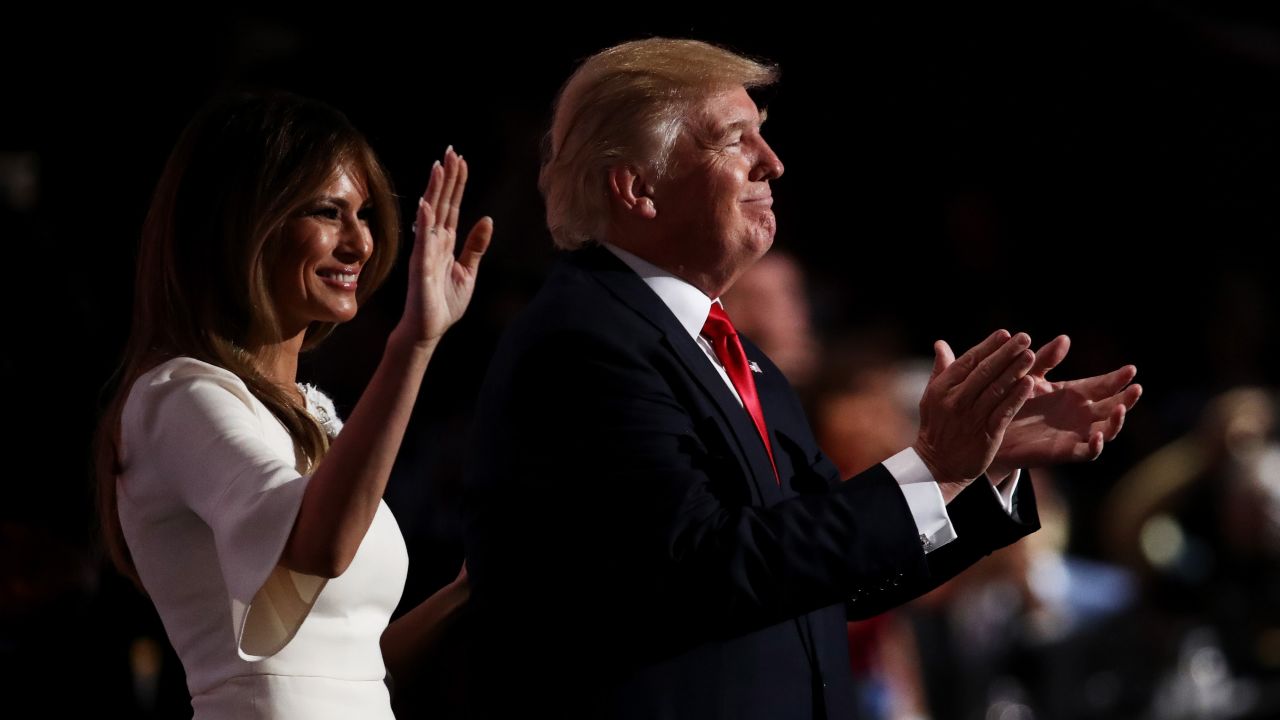 Trump claps on stage with his wife, Melania.