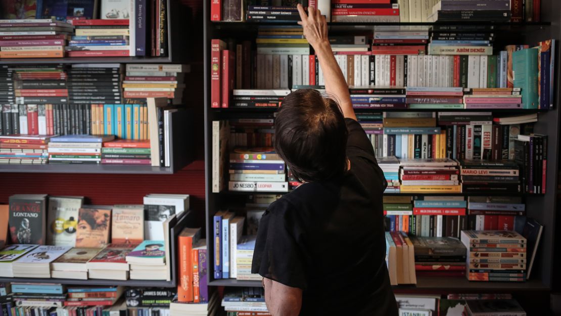 Nuran, a bookstore owner, poses for a photo in her shop, in Istanbul.