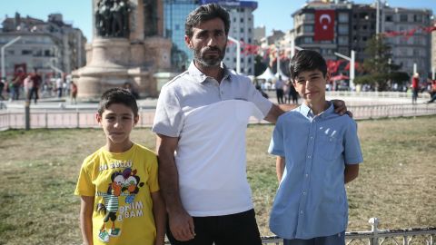 Taner, a construction worker, poses for a photo with his sons in Taksim Square, in Istanbul.
