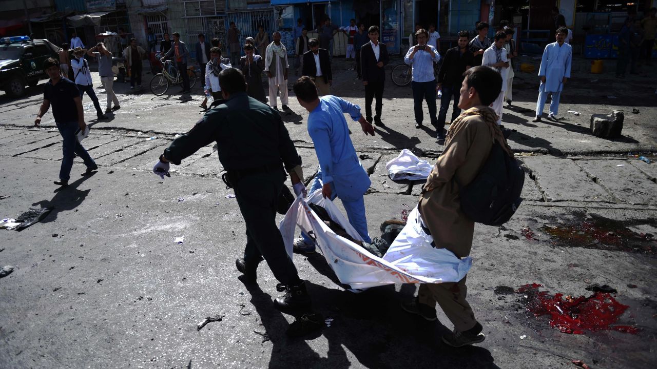 Afghan volunteers carry the bodies of victims.