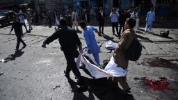 Afghan volunteers carry the bodies of victims at the scene of a suicide attack that targeted crowds of minority Shiite Hazaras during a demonstration at the Deh Mazang Circle of Kabul on Saturday, July 23.